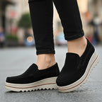 Black loafer shoe with a white sole on a white background
